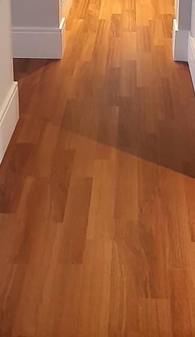 Piso laminado amadeirado instalado em corredor residencial
